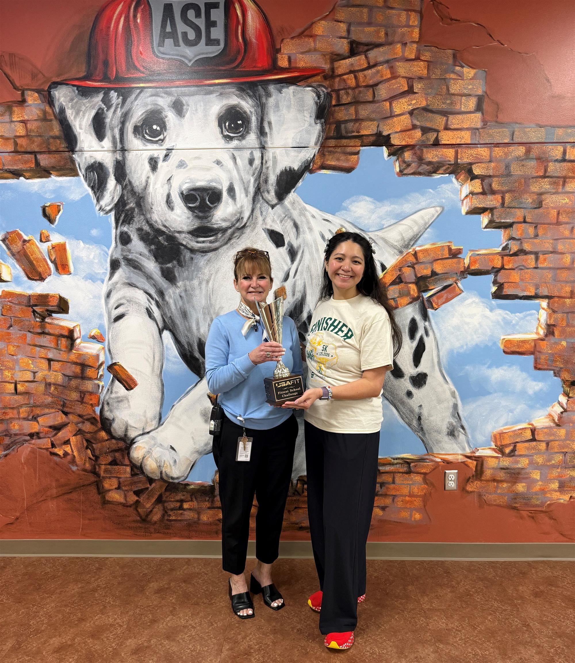 Principal and lady holding trophy 